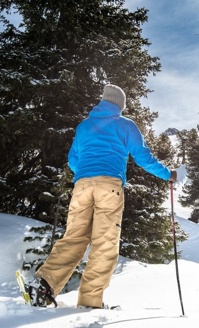 Schneeschuhwandern am Graukogel Schneeschuhwanderer stapft durch den verschneiten Wald am Graukogel