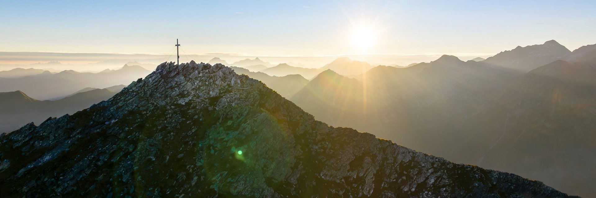 Dieses Bild zeigt den Graukogel mit Gipfelkreuz bei abendlicher Stimmung