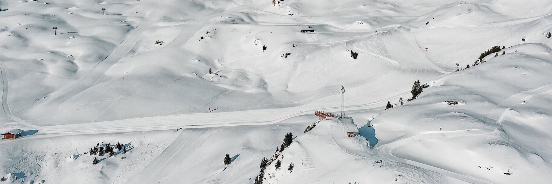 Drohnenaufnahme von traumhaftem Winter-Bergpanorama mit Piste H4 und Schlossalmblick