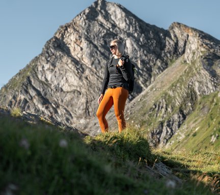 Dieses Bild zeigt eine Frau, die bei perfektem Wetter auf den Graukogel wandert.