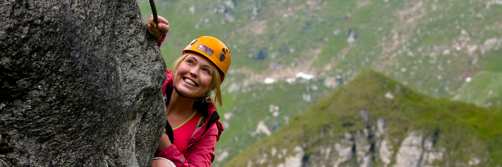 Auf diesem Bild ist zu sehen, wie eine Frau auf einem Klettersteig zum Hochalmblick in Gastein klettert