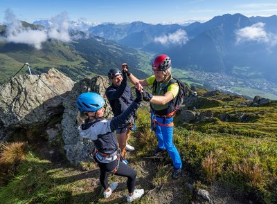 Dieses Bild zeigt eine Gruppe, die einen Klettersteig auf der Schlossalm erfolgreich abgeschlossen haben und sich darüber freuen