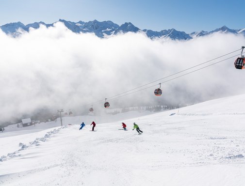 ALL-IN Card White Dieses Bild zeigt eine Gruppe von Skifahrern, die auf einer Piste in Gastein fährt