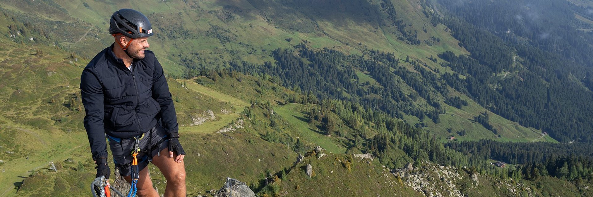 Dieses Bild zeigt eine Gruppe, die den Klettersteig Hirschinger in Gastein in luftiger Höhe besteigt