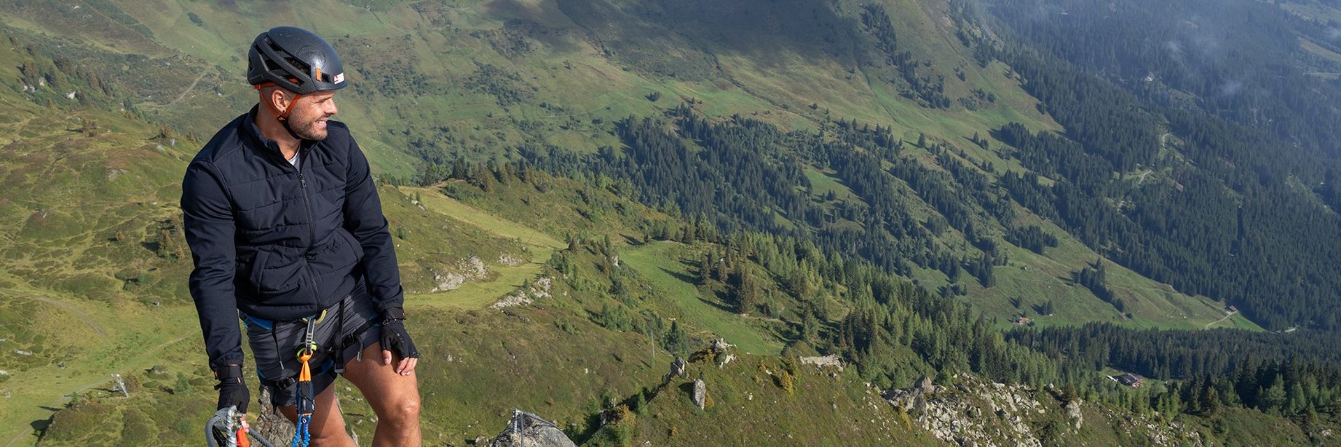 Dieses Bild zeigt eine Gruppe, die den Klettersteig Hirschinger in Gastein in luftiger Höhe besteigt