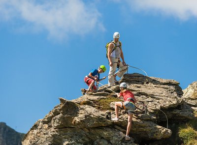 Dieses Bild zeigt einen Mann und zwei Kinder, die in einem Trittsicherheitsparcour in Gastein klettern