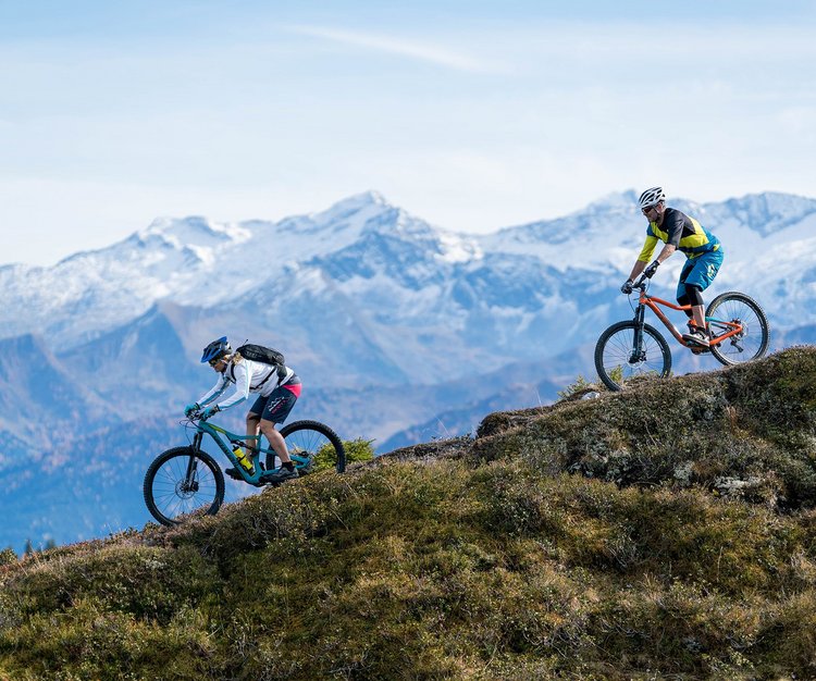 Dieses Bild zeigt zwei Mountainbiker, die einen Berg in Gastein hinunterfahren 