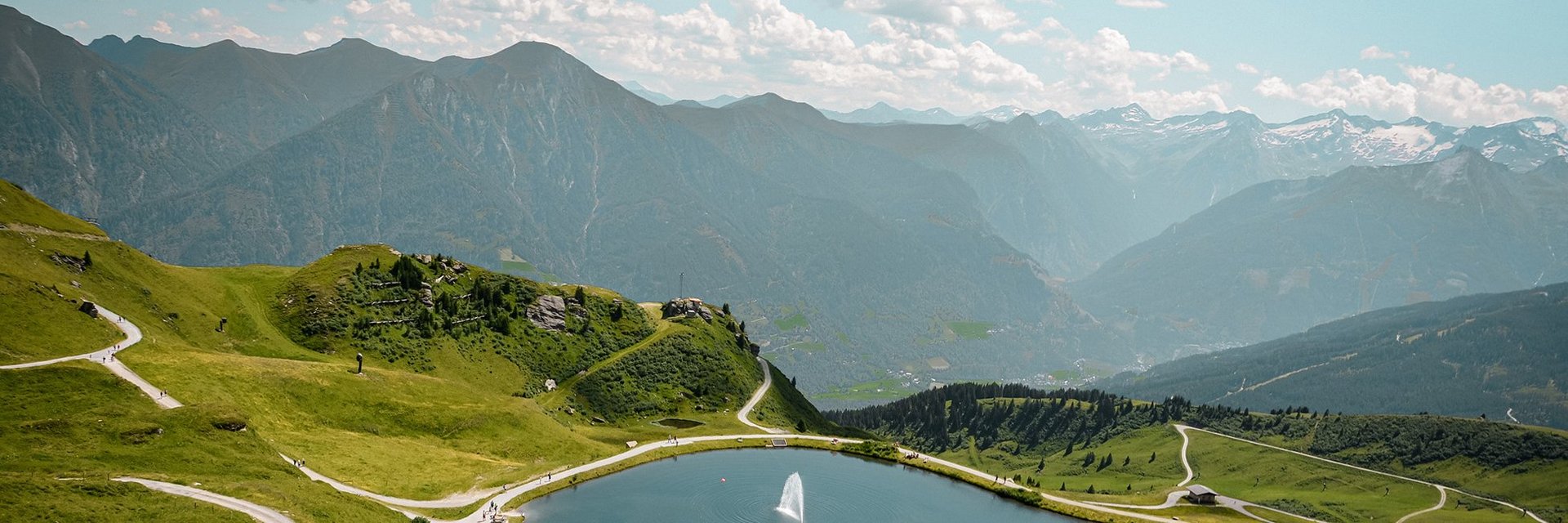 Dieses Bild zeigt eine Luftaufnahme von dem Schlossalmsee mit zwei Wasserfontänen