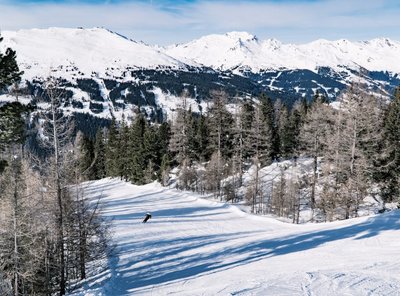 Die Skiabfahrt am Graukogel mit Ausblick auf die verschneiten Berge