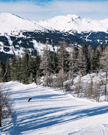 Graukogel Die Skiabfahrt am Graukogel mit Ausblick auf die verschneiten Berge