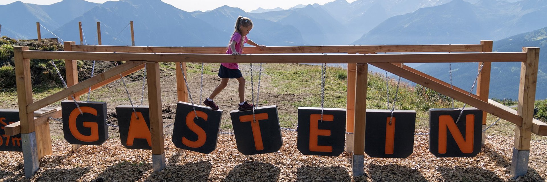 Dieses Bild zeigt ein Mädchen, dass im Motorikweg auf der Schlossalm balanciert