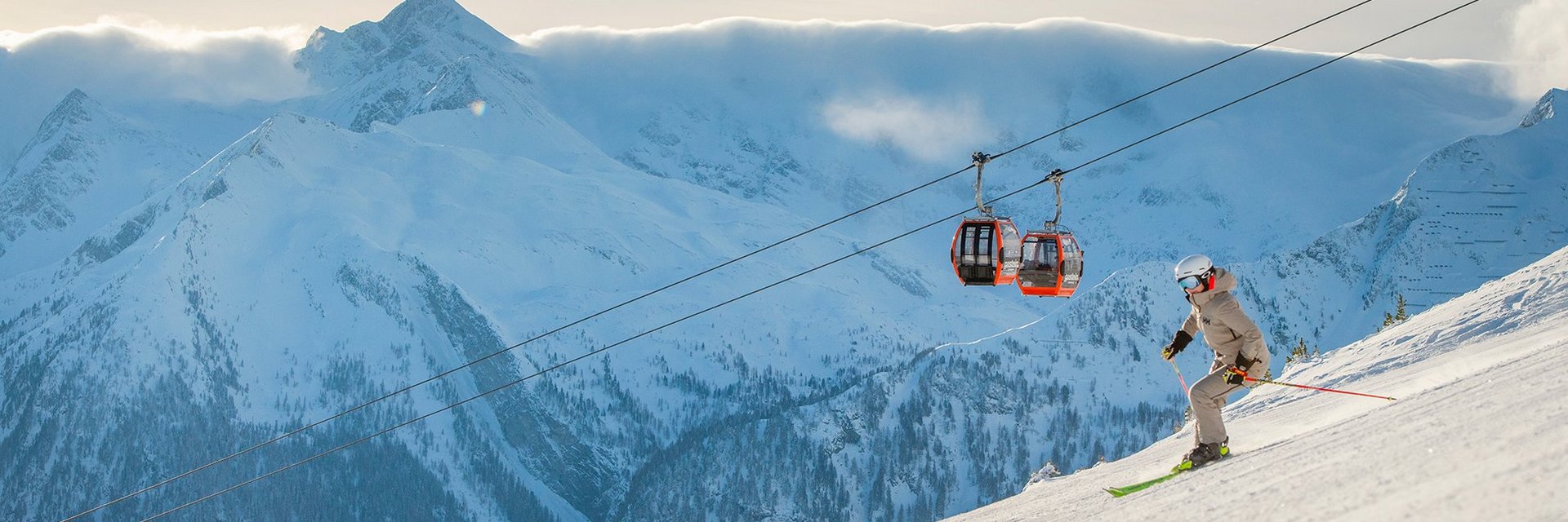 Dieses Bild zeigt einen Skifahrer am Stubnerkogl auf der Piste fahren, mit der Gondelbahn im Hintergrund