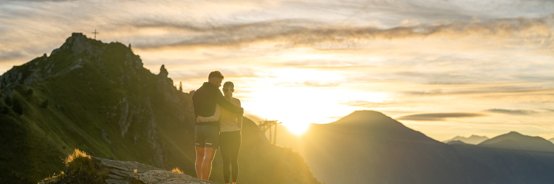 Dieses Bild zeigt ein Pärchen, dass einen malerischen Sonnenaufgang auf der Schlossalm genießt