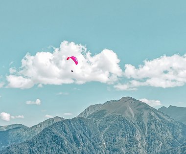 Dieses Bild zeigt einen Paragleiter, der über Gastein fliegt