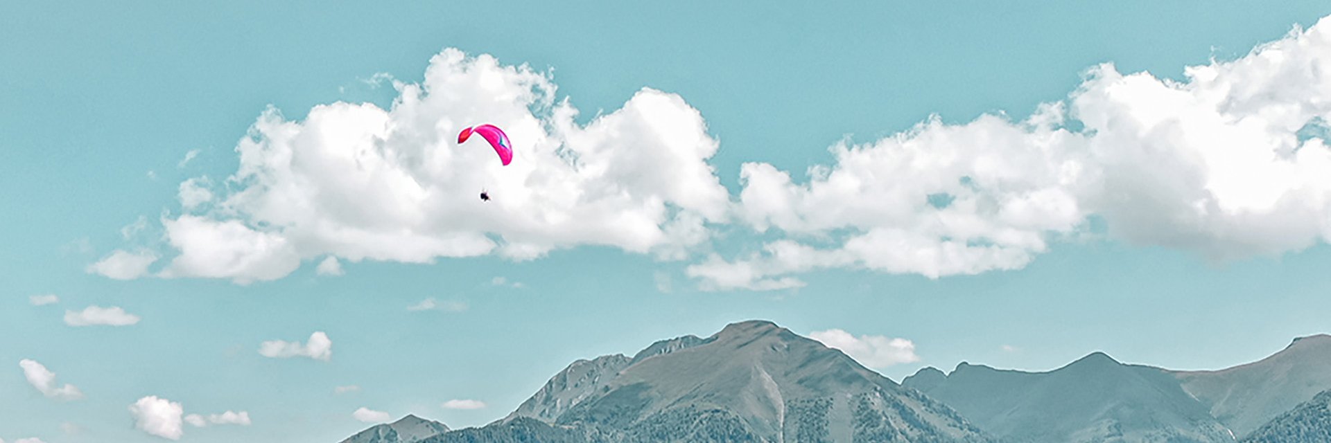 Dieses Bild zeigt einen Paragleiter, der über Gastein fliegt