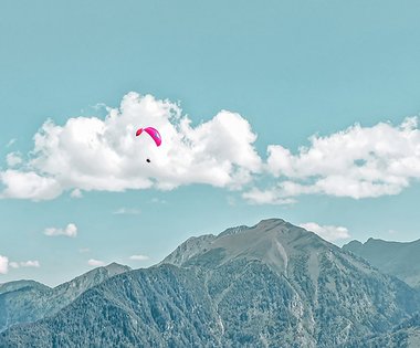 Dieses Bild zeigt einen Paragleiter, der über Gastein fliegt