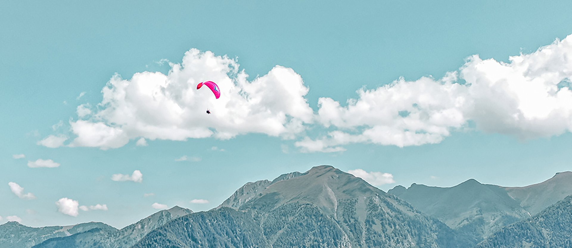 Dieses Bild zeigt einen Paragleiter, der über Gastein fliegt