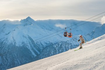 Dieses Bild zeigt einen Skifahrer auf einer Piste am Stubnerkogel mit der Gondelbahn im Hintergrund
