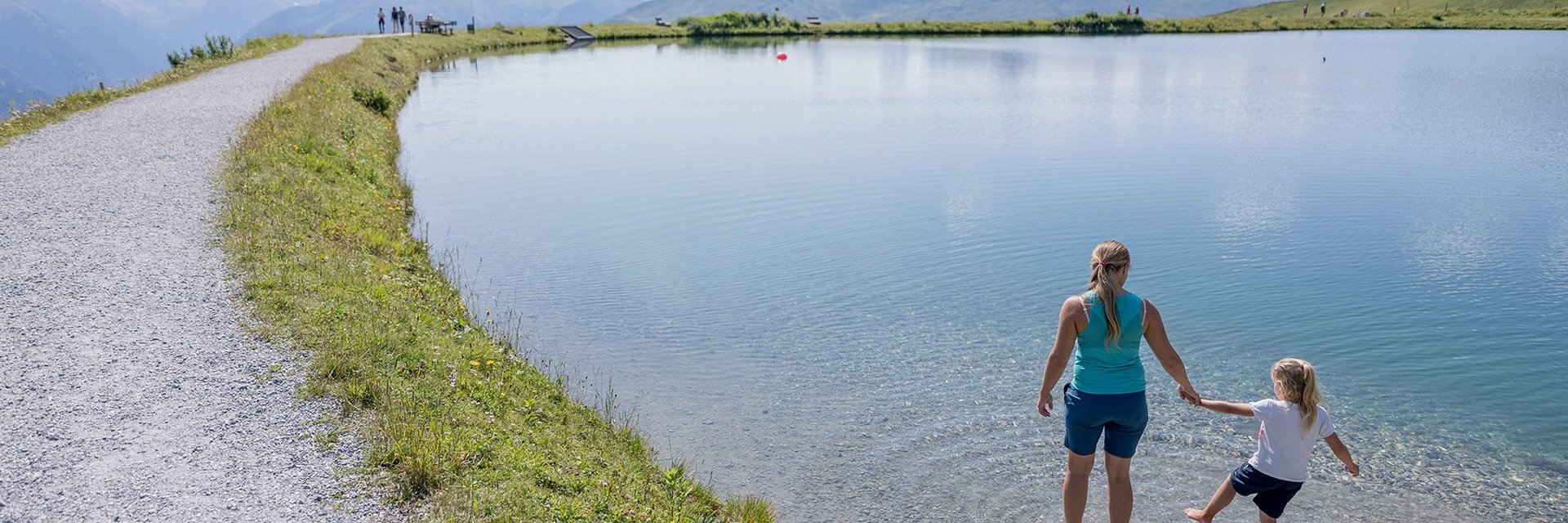 Dieses Bild zeigt Mutter und Tochter, die sich im Schlossalmsee die Füße abkühlen