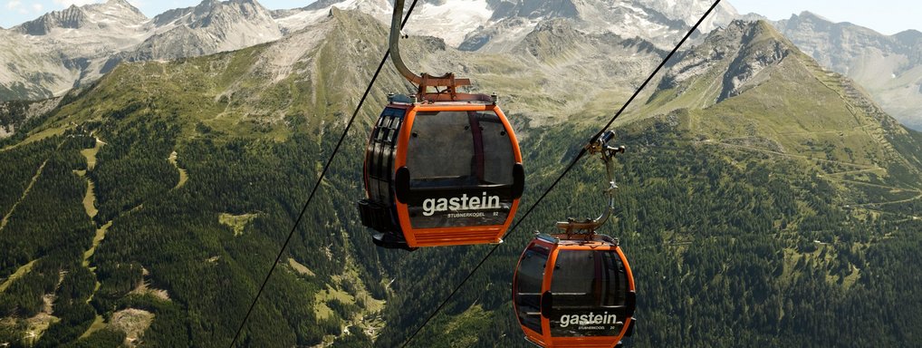 Sommertickets  Dieses Bild zeigt zwei Gondeln der Stubnerkogelbahn mit einem sommerlichen Bergpanorama im Hintergrund
