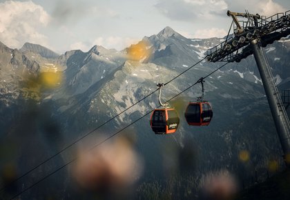 Dieses Bild zeigt zwei Gondeln und eine Stütze der Stubnerkogelbahn am Abend