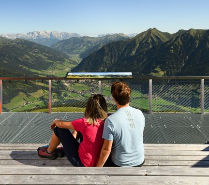 Pärchen schaut von der Aussichtsplattform Talblick in die Bergwelt