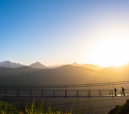 Dieses Bild zeigt die Hängebrücke auf dem Stubnerkogel. Im Hintergrund geht die Sonne unter