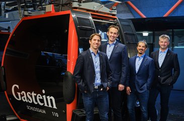 Die Geschäftsleitung der Gasteiner Bergbahnen posiert vor einer Gondel der Schlossalmbahn.