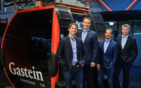 Die Geschäftsleitung der Gasteiner Bergbahnen posiert vor einer Gondel der Schlossalmbahn.